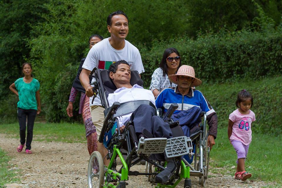 The author, Pankaj Pradhananga, pushes a wheelchair. © Four Season Travel & Tours